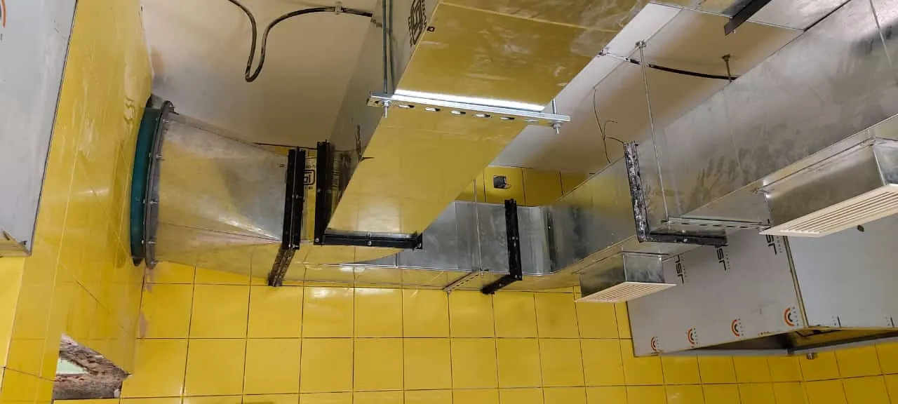 Galvanised ducting routed across a kitchen ceiling with support brackets