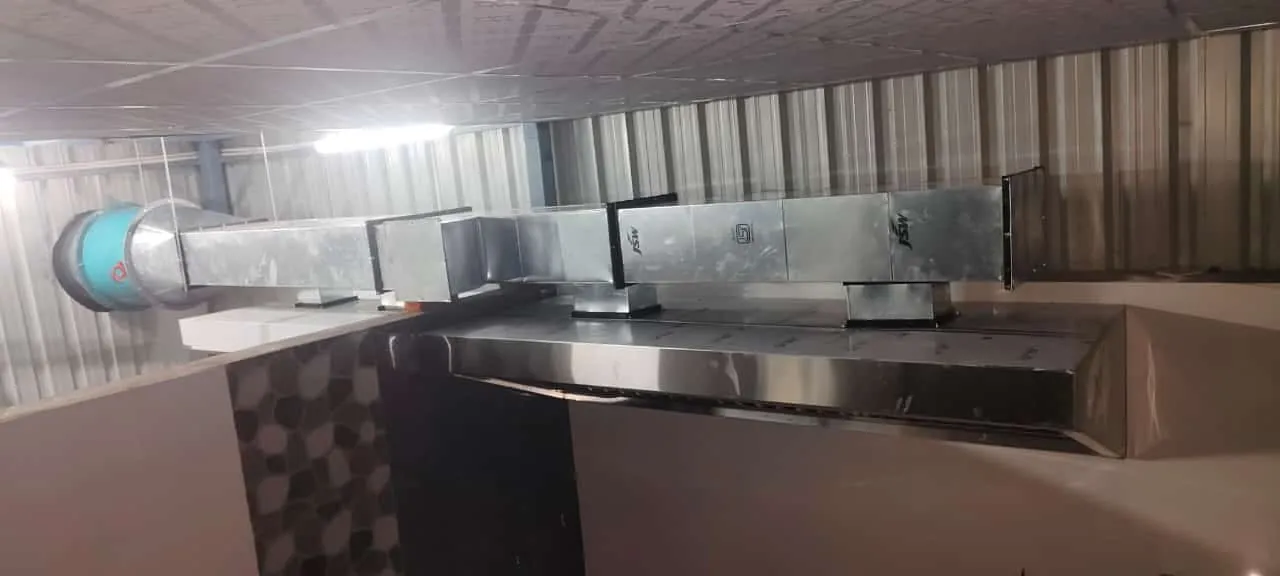 Kitchen hood joined to a round insulated duct running across the ceiling