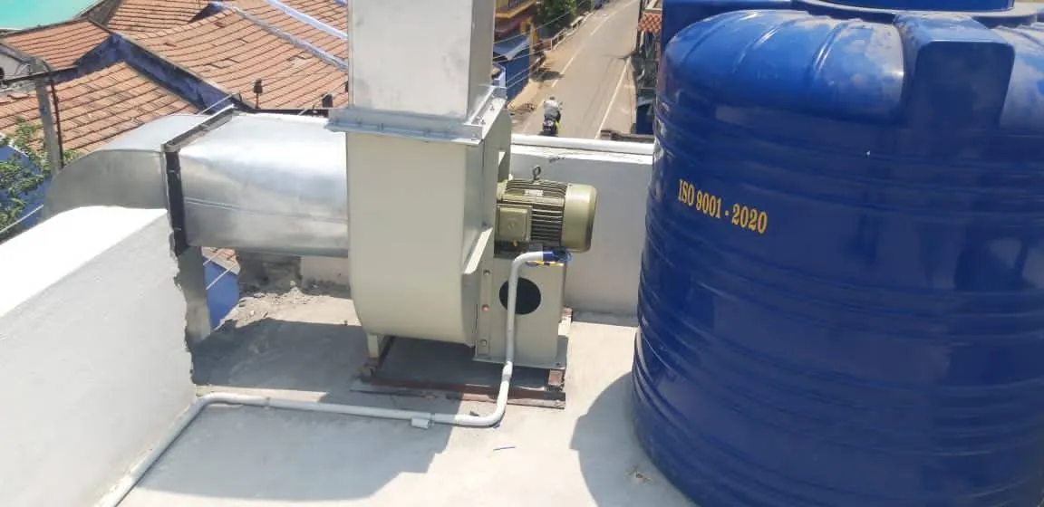 Rooftop blower unit with motor and belt drive beside a water tank